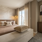 photo d'une chambre décorée avec des éléments modernes, dans les tons beige et marron, un pan de mur feuillu et des luminaires de chaque côté du lit