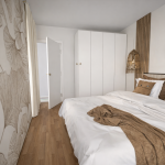 photo d'une chambre dans les tons beige et marron clair avec un lit dans les mêmes couleurs , des luminaires en rotin et un pan de mur décoré avec une tapisserie ornée de feuilles de ginko biloba, de couleur beige
