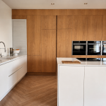 cuisine moderne avec placards en bois intégrés et un îlot central blanc laqué