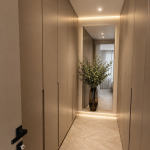 photo d'un dressing avec placards beige de part et d'autres du passage et un miroir au fond de la pièce
