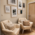 photo de deux fauteuils jumeaux aux couleurs beige agrémentés de coussins dans les mêmes tons et des cadres décoratifs au mur