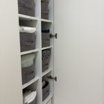 photo d'un placards à vêtements parfaitement rangé, organisé avec des boîtes en tissu