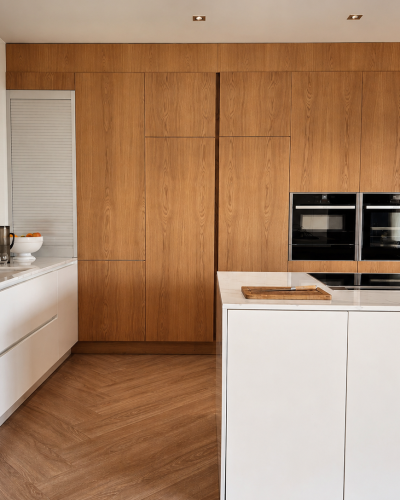 cuisine moderne avec placards en bois intégrés et un îlot central blanc laqué